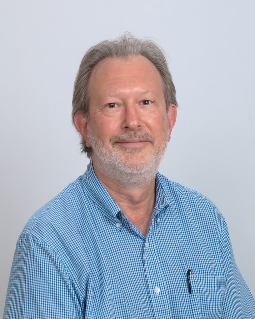 Portrait of a friendly middle-aged man with a light beard and blue checkered shirt.