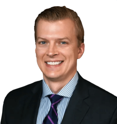 Professional headshot of a young man in a suit, exuding confidence and approachability.