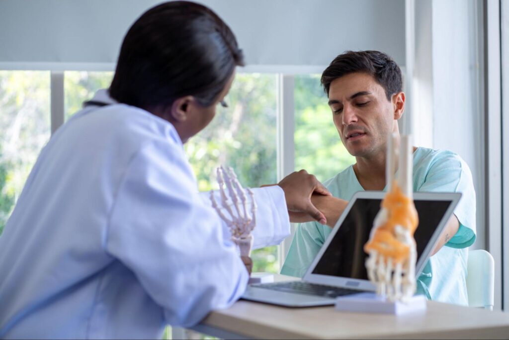 Engaged doctor-patient consultation with technology and educational tools in a bright clinic.