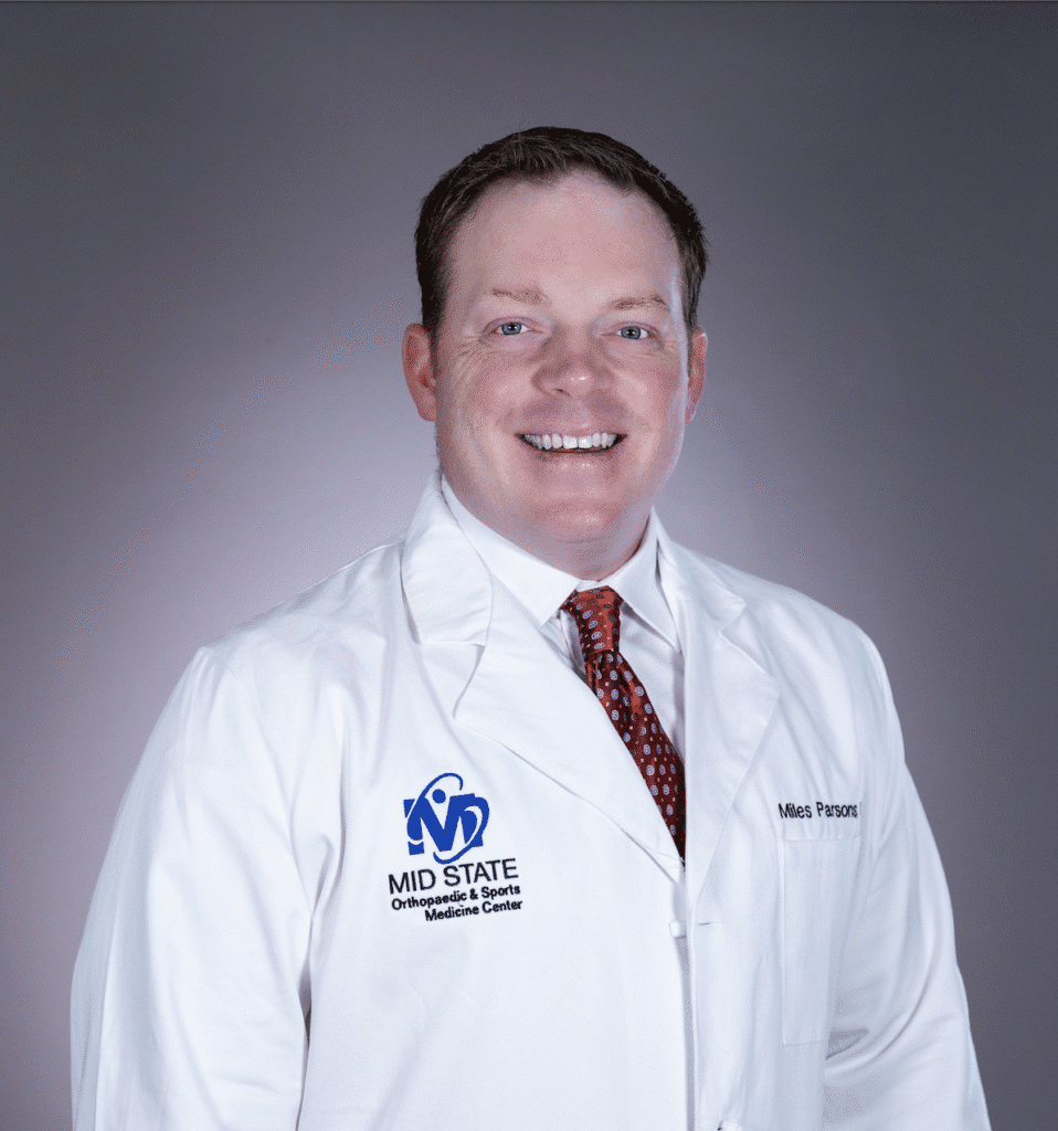 Dr. Miles Parsons in a white lab coat at MID STATE Orthopedic & Sports Medicine Center.
