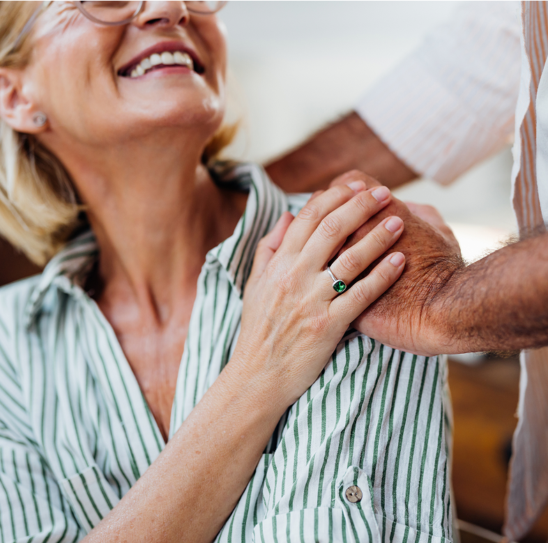 Relaxed, awake and comfortable couple resting hands together on shoulder.